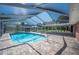 Screened-in pool area with brick patio, pool with handrail and covered area with view of landscaped yard at 5604 Stratford Ln, Lakeland, FL 33813