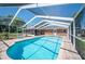 Backyard pool with clear blue water, brick house, and a screened lanai at 5604 Stratford Ln, Lakeland, FL 33813