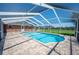 Screened-in pool and patio area with brick house and green backyard view with blue sky at 5604 Stratford Ln, Lakeland, FL 33813