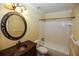 Bright bathroom featuring a bathtub, toilet, vanity, decorative mirror, and natural lighting at 6131 Doe E Cir, Lakeland, FL 33809