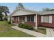 Charming brick home featuring a cozy front porch, white accents, and well-maintained landscaping at 6131 Doe E Cir, Lakeland, FL 33809