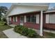 Charming brick home featuring a cozy front porch, white accents, and well-maintained landscaping at 6131 Doe E Cir, Lakeland, FL 33809