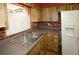 Traditional kitchen with stainless steel sink, white refrigerator, brick accent wall, and wood cabinets at 6131 Doe E Cir, Lakeland, FL 33809