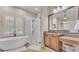Elegant bathroom with a freestanding tub, walk-in shower, granite countertops, and plantation shutters at 6546 Eagle View Loop, Lakeland, FL 33813