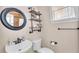 Charming half bathroom featuring a sink, toilet, round mirror and shelving at 6546 Eagle View Loop, Lakeland, FL 33813