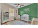 Inviting Bedroom with a white crib, chair, patterned rug, and green accent wall at 6546 Eagle View Loop, Lakeland, FL 33813