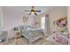 Bright bedroom with pink walls, ceiling fan, floral bedding, and natural light from the window at 6546 Eagle View Loop, Lakeland, FL 33813