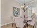 Elegant dining room featuring a round wooden table, upholstered chairs, a chandelier, and a large bay window at 6546 Eagle View Loop, Lakeland, FL 33813