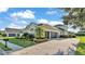 A beautiful home showcases an extended three-car garage and lush landscaping with a stone paver driveway at 6546 Eagle View Loop, Lakeland, FL 33813