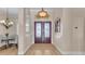 Warm and inviting foyer with wood floors, decorative double doors, and elegant lighting fixture at 6546 Eagle View Loop, Lakeland, FL 33813