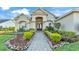 The home boasts a charming entrance with manicured landscaping, a stone paver walkway, and a double-door entryway at 6546 Eagle View Loop, Lakeland, FL 33813