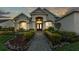 Charming home with a manicured lawn, stone accents, and an inviting entrance and well lit porch at 6546 Eagle View Loop, Lakeland, FL 33813