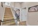 Hallway with carpeted stairs, wood floors, iron railing, and view into the bedroom at 6546 Eagle View Loop, Lakeland, FL 33813