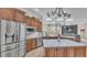 Open kitchen with stainless steel appliances, large island with countertop seating, and wood cabinetry at 6546 Eagle View Loop, Lakeland, FL 33813
