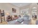 Bright living room featuring a leather sofa, plush armchair, and sliding doors with a view of the backyard and pool at 6546 Eagle View Loop, Lakeland, FL 33813
