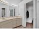 Bathroom featuring double sinks, large mirror, and door to a walk-in closet at 6750 Lemon Tree Dr, Lakeland, FL 33813