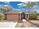 Charming home featuring a two-car garage, well-kept lawn, and delightful front entryway at 6750 Lemon Tree Dr, Lakeland, FL 33813