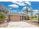 Single-story home with a two-car garage, palm tree, and front lawn at 6750 Lemon Tree Dr, Lakeland, FL 33813