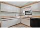 Efficient kitchen design featuring white cabinets and tile flooring at 6750 Lemon Tree Dr, Lakeland, FL 33813