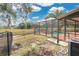 A screened-in pool has a privacy fence and patio and overlooks the large, grassy backyard of the home at 6750 Lemon Tree Dr, Lakeland, FL 33813