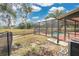 A screened-in pool has a privacy fence and patio and overlooks the large, grassy backyard of the home at 6750 Lemon Tree Dr, Lakeland, FL 33813