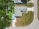 Bird's eye view of home with gray roof, showing backyard with utility building, surrounded by green trees at 6810 Palomino Dr, Lakeland, FL 33811