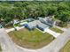 Wide aerial view of the property surrounded by mature trees, showcasing the yard and driveway at 6810 Palomino Dr, Lakeland, FL 33811