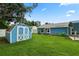 Backyard featuring a storage shed, well-manicured lawn, and view of the house at 6810 Palomino Dr, Lakeland, FL 33811