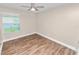 Bedroom featuring wood floors, a ceiling fan, a window, and neutral-colored walls at 6810 Palomino Dr, Lakeland, FL 33811