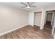 Bedroom with wood-look floors, a ceiling fan, a closet with a door a neutral-colored walls at 6810 Palomino Dr, Lakeland, FL 33811