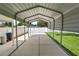 Spacious carport with a concrete base, adjacent to a fenced yard and landscaping at 6810 Palomino Dr, Lakeland, FL 33811