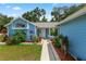 Inviting front entrance, with a walkway surrounded by garden beds filled with colorful flowers and green plants at 6810 Palomino Dr, Lakeland, FL 33811