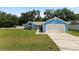 Cozy blue home with a two-car garage, beautiful landscaping and a well maintained green lawn at 6810 Palomino Dr, Lakeland, FL 33811