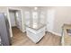 Kitchen island with granite countertop and white cabinets, illuminated by natural light from nearby windows at 6810 Palomino Dr, Lakeland, FL 33811
