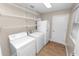 A laundry room featuring white appliances, shelving, and wood-look flooring at 6810 Palomino Dr, Lakeland, FL 33811