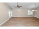 Open-concept living room featuring wood-look floors, a ceiling fan, and a sliding glass door leading to the outdoors at 6810 Palomino Dr, Lakeland, FL 33811