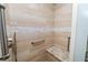 The tiled shower features a built-in bench, handrails, and sleek fixtures at 6810 Palomino Dr, Lakeland, FL 33811