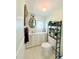Bright bathroom featuring white cabinets, an oval mirror, and decor atop a toilet shelf at 816 Elizabeth Ln, Lakeland, FL 33809