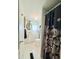 Bright bathroom with white vanity and decorated toilet visible behind a floral shower curtain at 816 Elizabeth Ln, Lakeland, FL 33809