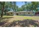 Expansive backyard featuring lush green grass, mature trees, and partial fencing, perfect for outdoor activities at 921 Avon Ave, Lakeland, FL 33801