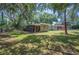 Serene backyard showcasing mature trees, lush greenery, and a view of the home with a screened-in porch at 921 Avon Ave, Lakeland, FL 33801