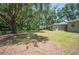 Large backyard with mature trees providing shade, featuring a well-maintained lawn and a glimpse of the home at 921 Avon Ave, Lakeland, FL 33801