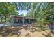 Charming home exterior featuring a screened-in porch, covered patio, and lush, mature landscaping at 921 Avon Ave, Lakeland, FL 33801