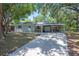 Charming home featuring a large driveway, a carport, and mature trees, offering a serene and inviting atmosphere at 921 Avon Ave, Lakeland, FL 33801