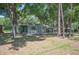 Inviting single-Gathering home nestled amongst mature trees, featuring a carport and well-manicured front lawn at 921 Avon Ave, Lakeland, FL 33801