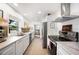 Galley kitchen featuring stainless appliances, tile floors and white cabinets at 921 Avon Ave, Lakeland, FL 33801