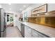 Galley kitchen featuring stainless appliances, tile floors, white cabinets and marble countertops at 921 Avon Ave, Lakeland, FL 33801