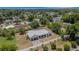 An aerial view showcases the home's location in a lush neighborhood with mature trees, and landscaped yards at 1 Brogden Se Ct, Winter Haven, FL 33880