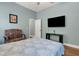 Bedroom with a TV, sitting chair, wood floors, and light blue walls at 1 Brogden Se Ct, Winter Haven, FL 33880