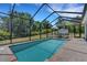 Sparkling blue swimming pool with screened enclosure, hot tub, and lush landscaping for a relaxing outdoor oasis at 1 Brogden Se Ct, Winter Haven, FL 33880